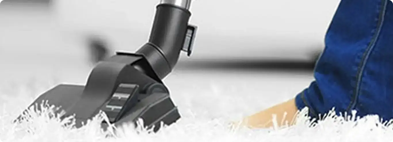 Close-up of a professional vacuuming a white carpet in Tolleson.